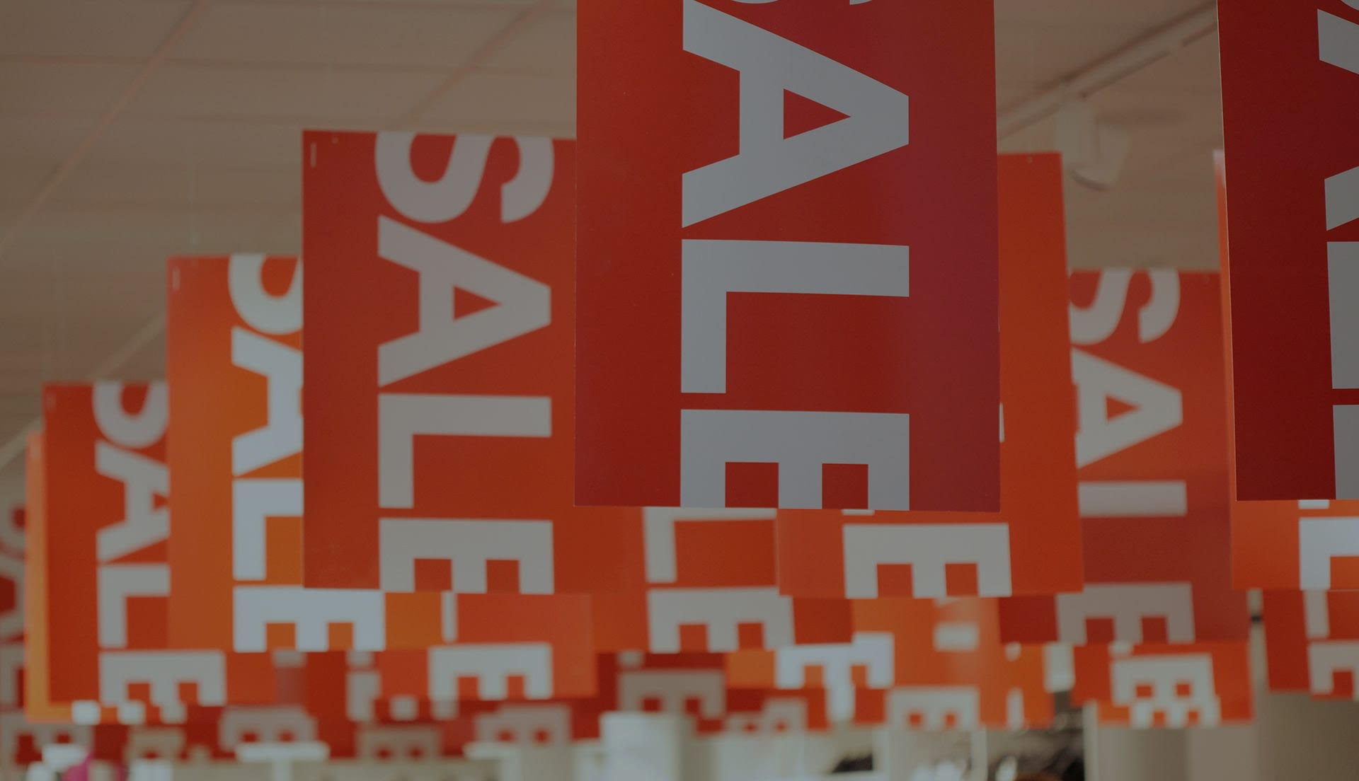 find an undervalued stock: red signs displaying the word 'sale' hang from the ceiling