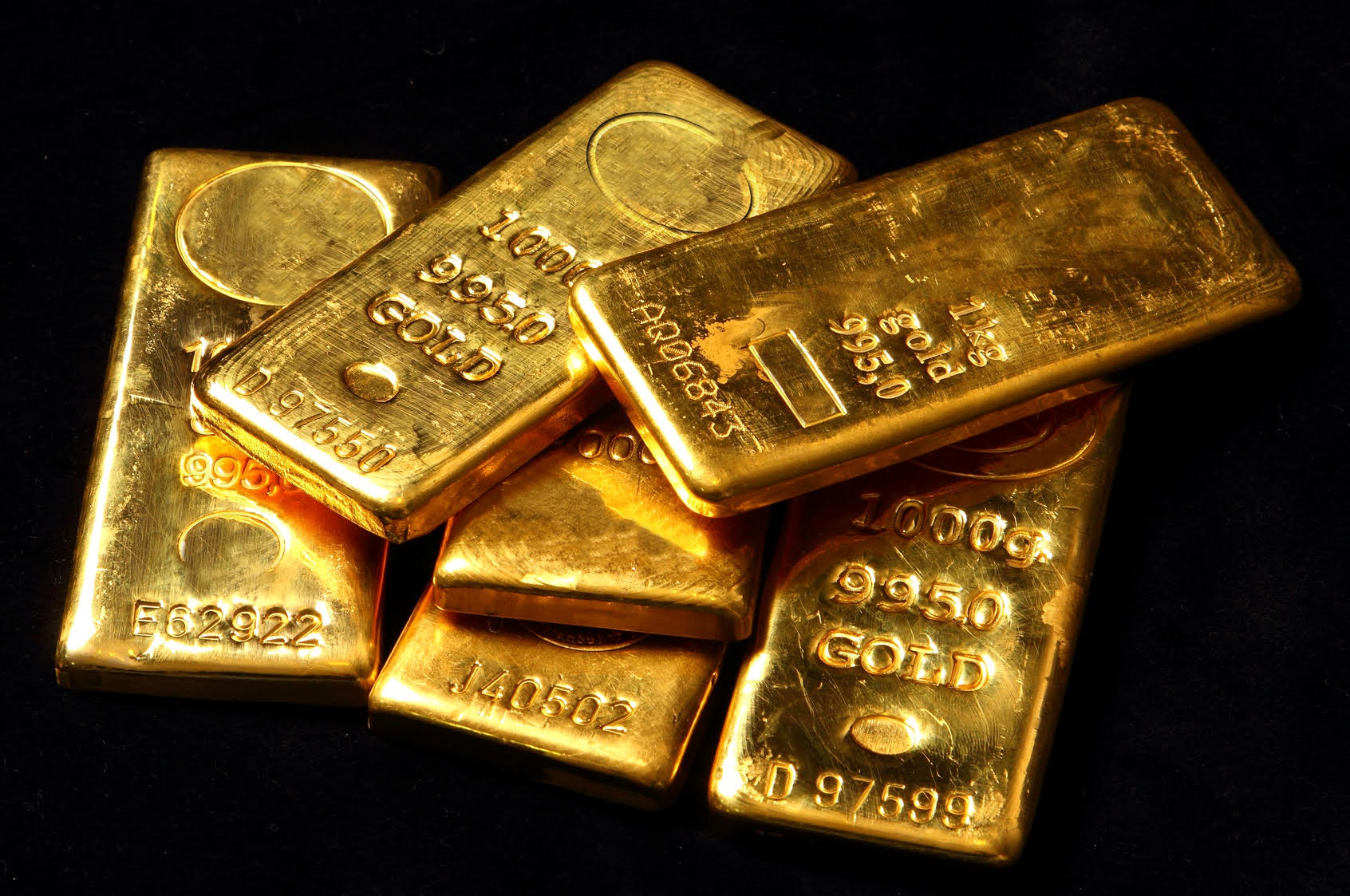 Invest in gold: six 1000g bars on a black background
