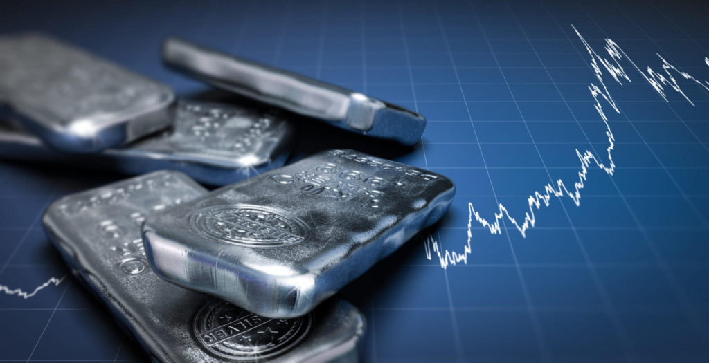 Invest in silver: Five silver bars in front of a blue stock market graph
