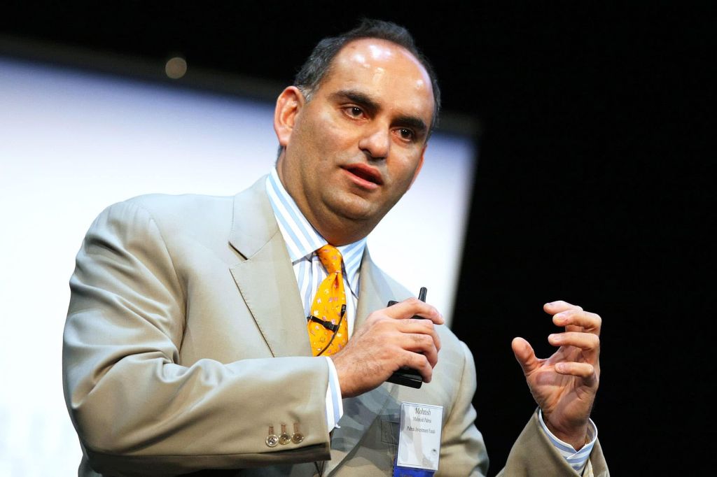 Mohnish Pabrai: An Indian businessman giving a speech with a projector behind