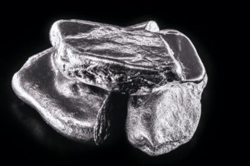 Platinum vs palladium: raw platinum and palladium ingots on a black background