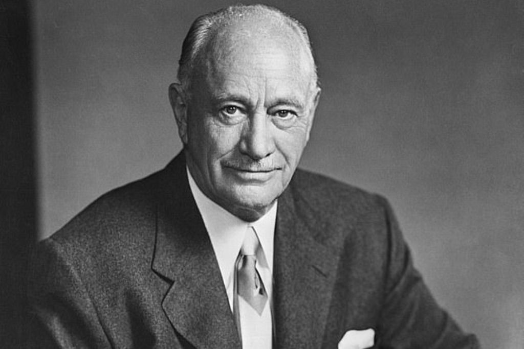 Conrad Hilton: a black and white photo of a well-dressed man in a suit staring into the camera